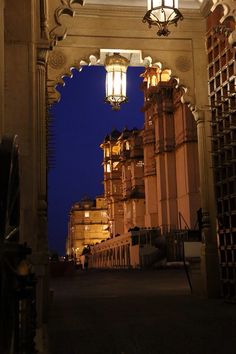 an archway leading into a building with lights hanging from it's sides at night