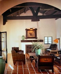 a living room filled with furniture and a fire place in the middle of a room