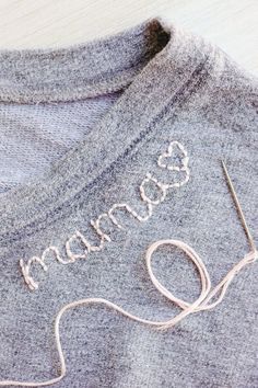 a close up of a sweater with the word love written on it and a pair of scissors