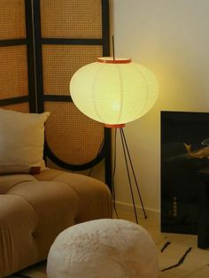 a living room with a couch, lamp and painting on the wall next to it