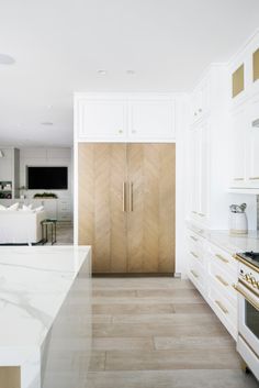 a large kitchen with white cabinets and marble counter tops, along with an island in the middle