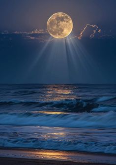 the full moon is shining brightly over the ocean