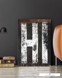 an old rusty metal sign with the letter h on it in front of a chair