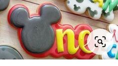 mickey mouse cookies with the word disney spelled out in front of them on a wooden surface