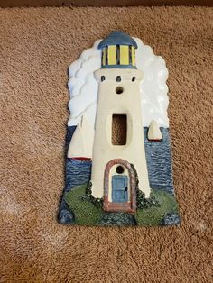 a ceramic lighthouse on the ground with clouds