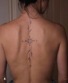 a woman with a cross tattoo on her back