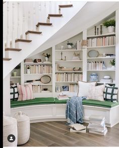 a room with bookshelves, pillows and other items on the shelves in it