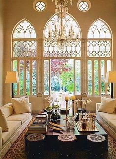 a living room filled with furniture and a chandelier hanging over the top of it