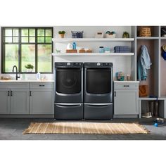 the front load washer and dryer are shown in this kitchen setting with open shelving