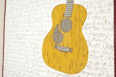 an acoustic guitar is on display in front of a wall with words written all over it