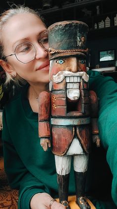 a woman kissing a wooden nutcracker statue