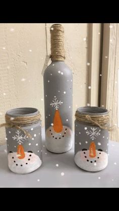 three glass bottles with snowmen on them