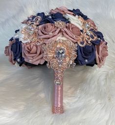 the bridal bouquet is made up of pink, blue and white flowers with pearls