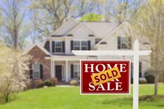 a home for sale sign in front of a house