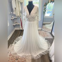 a white wedding dress on display in front of a mirror