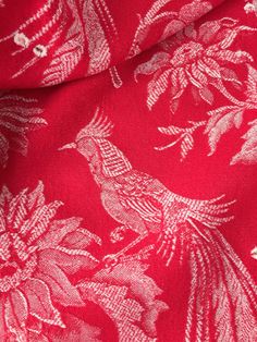 a red and white bird print fabric with silver foiling on it's side