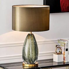 a table with a lamp on top of it and a book case next to it