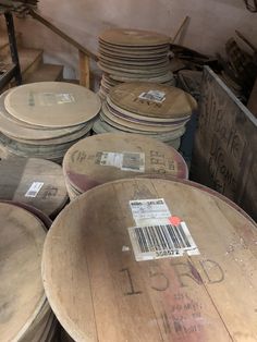 several wooden barrels stacked on top of each other in a room with shelves and signs