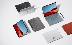 several different laptops and notebooks on a white surface with one open, the other closed