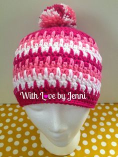 a pink and white knitted hat on top of a mannequin's head