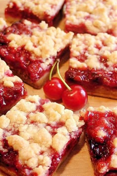 cherry crumbler bars on a cutting board with cherries