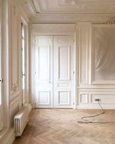 an empty room with white walls and wood floors