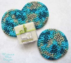 two crocheted coasters sitting next to each other