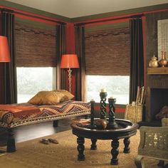 a cat laying on top of a bed in a room with red walls and curtains