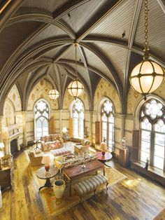 a large living room with wooden floors and arched windows