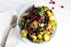 a white bowl filled with brussel sprouts and cranberry sauce