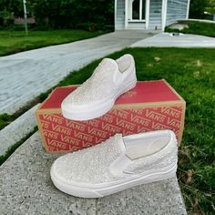 a pair of white shoes sitting on top of a box