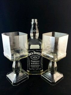 an assortment of liquor bottles and glasses sitting on top of each other in front of a black background