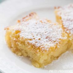 two pieces of cake on a plate with powdered sugar over it and one slice missing