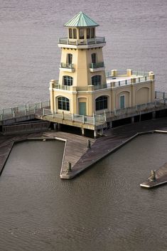 a light house sitting on top of a pier next to the ocean in front of a body of water