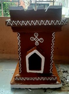 a brown and white dog house sitting on top of a cement floor next to a window