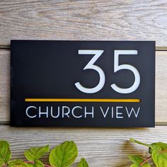 a black and white sign that reads 35 church view with green leaves on the side