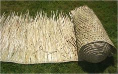 an area rug made out of grass and straw is laying on the ground with it's end rolled up