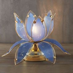 a blue and gold flower lamp on a wooden table