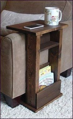 a wooden table with a book shelf underneath it and a coffee cup on the end