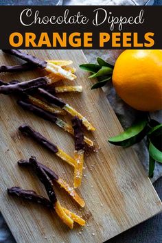 chocolate dipped orange peels on a cutting board next to an orange