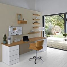 a desk with a laptop on it in front of a sliding glass door that leads to an outside patio