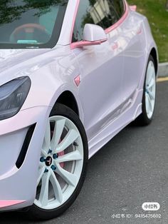 a white car with pink trim parked on the street