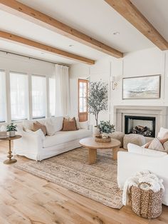 a living room filled with furniture and a fire place in the middle of a wooden floor