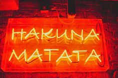 a neon sign that reads hakuna matata on it's side wall