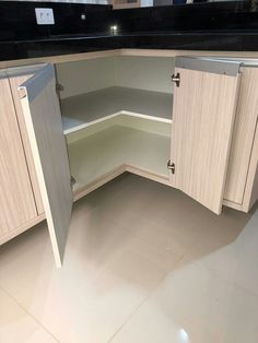 an empty corner cabinet in the middle of a kitchen