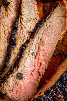 sliced meat sitting on top of a wooden cutting board