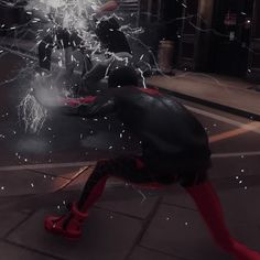 a spider - man in black and red is running on the street