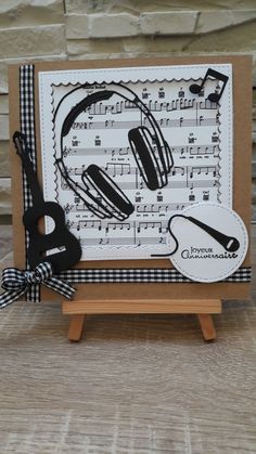 a handmade card with headphones and sheet music on it, sitting on a wooden stand