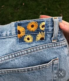 someone is showing off their jeans with sunflowers on the back pocket and side pockets