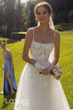 a woman in a wedding dress standing next to another woman